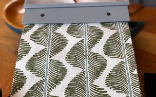 Grace upholstered headboard in Fabric&Frame Buxton Blue, shown on a white bed base in a modern bedroom.