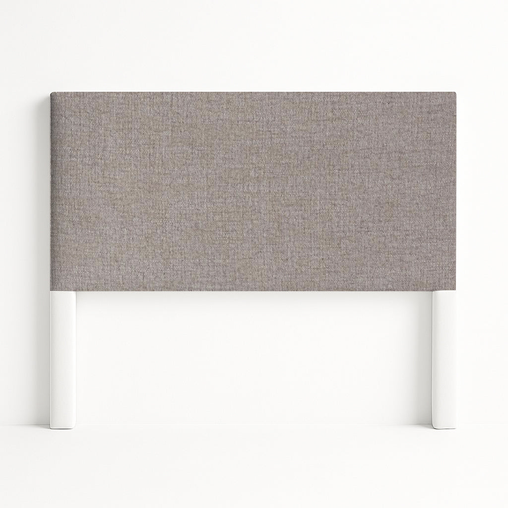 Iris upholstered headboard in Fabric&Frame Santorini, shown on a white bed base in a modern bedroom.
