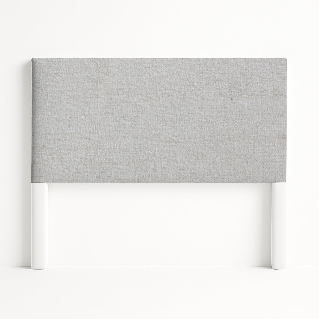 Iris upholstered headboard in Fabric&Frame Santorini, shown on a white bed base in a modern bedroom.
